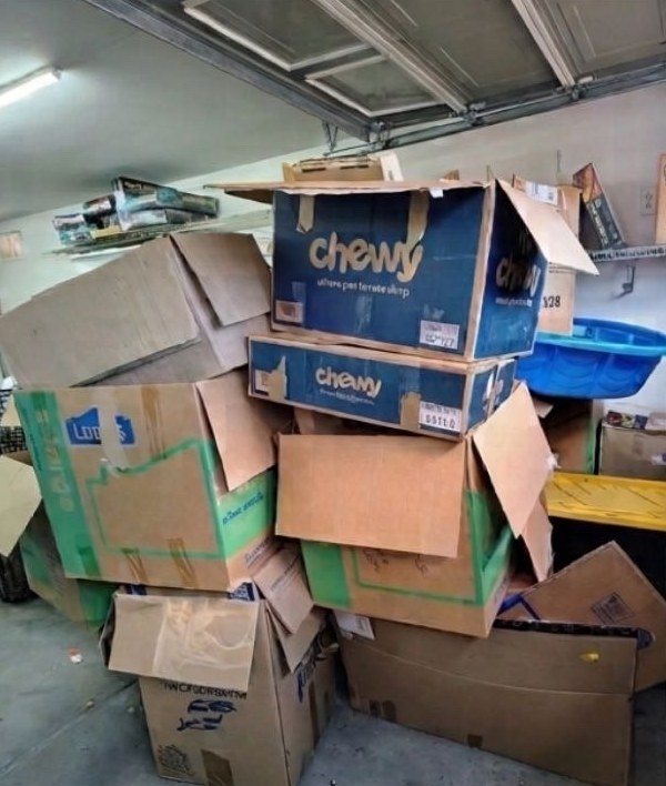 Garage packed to the ceiling with cardboard moving boxes before the cleanout