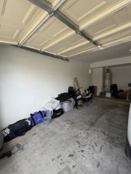 The same garage with appliances and boxes removed and the floor cleared