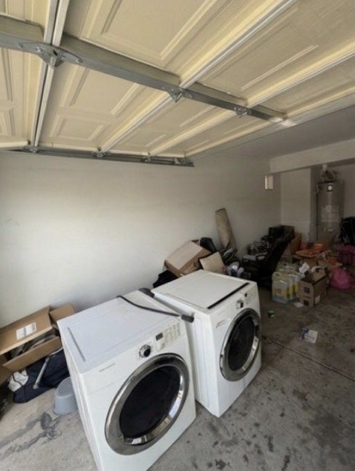Cluttered garage holding a washer, dryer and stacked boxes before the cleanout