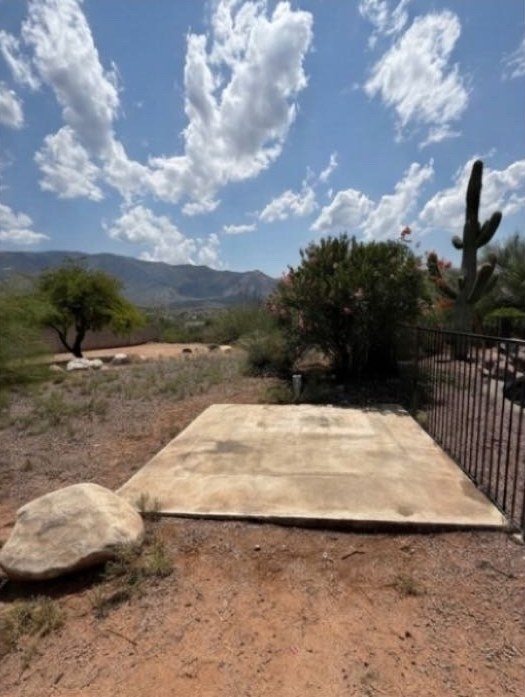 The same backyard with the hot tub removed, leaving a bare concrete pad